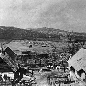 Pohled na vesničku, v pozadí chalupy Staré Huti a panoráma Medvědích hor s vrcholem Velký Zvon.